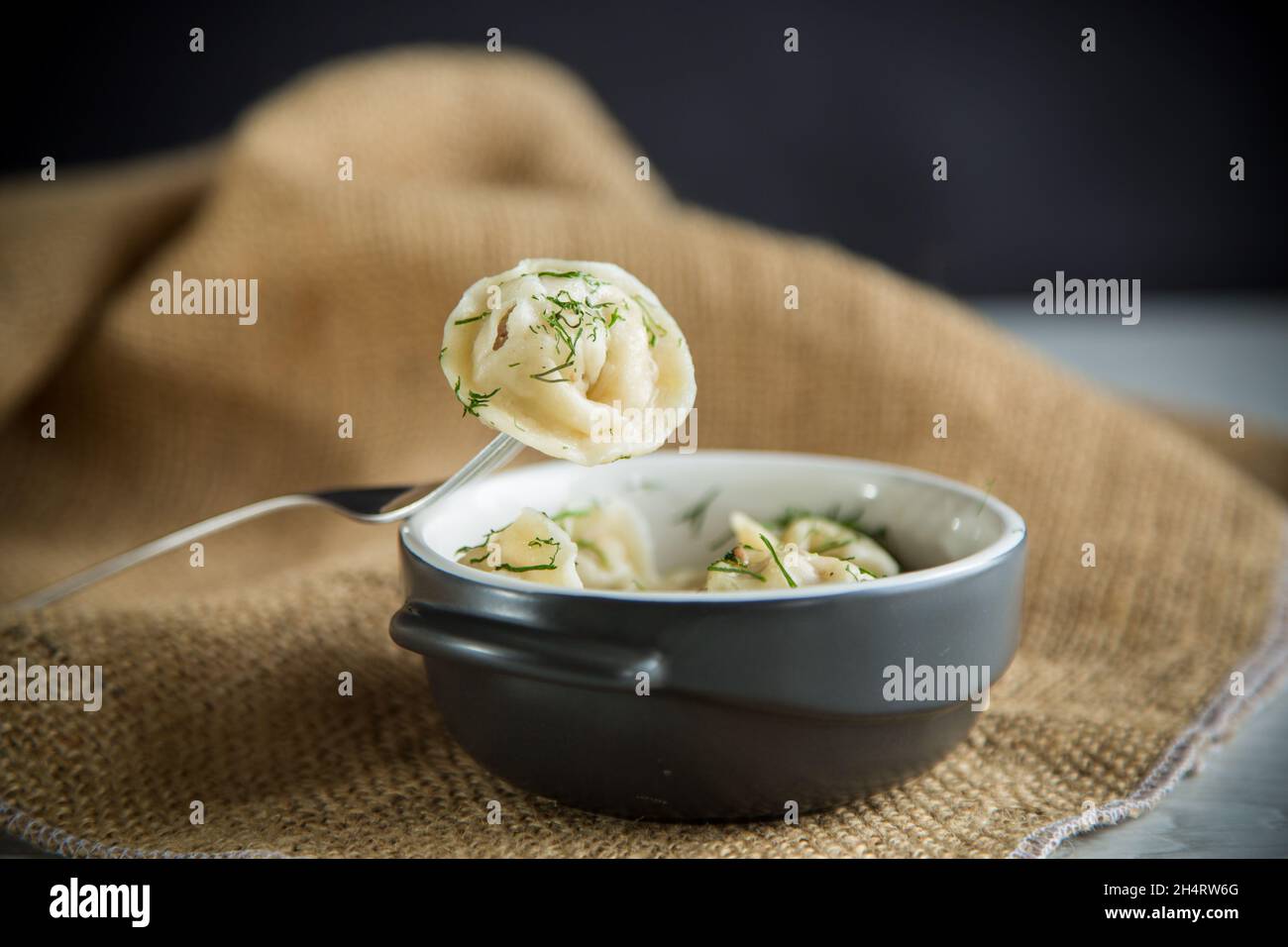 Gekochte Knödel mit Fleischfüllung in einer Schüssel auf dem Tisch Stockfoto