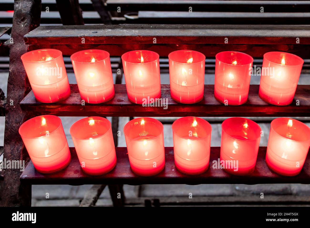 Regal mit brennenden Opferkerzen Stockfoto