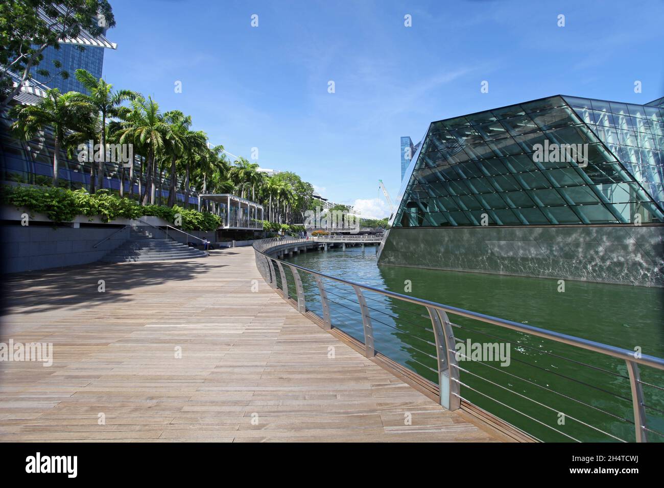 Ein Spaziergang entlang der Wasserfront am Marina Bay Sands mit dem Einkaufszentrum Shoppes auf der linken Seite und dem Louis Vuitton Shop auf der rechten Seite in Singapur. Stockfoto