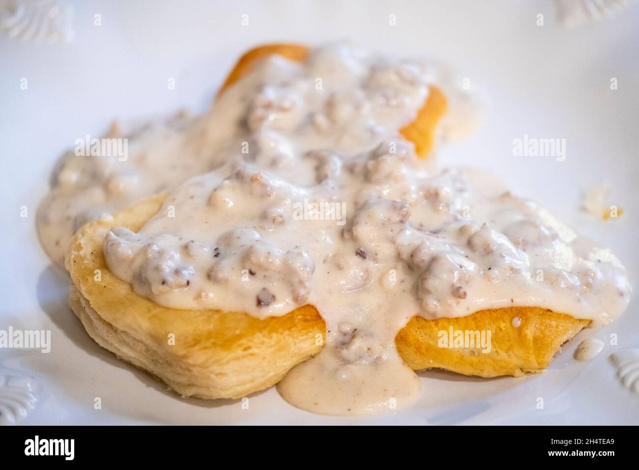 Wurst pfefferte Milchsoße über Biskuits auf einem weißen Teller. Stockfoto