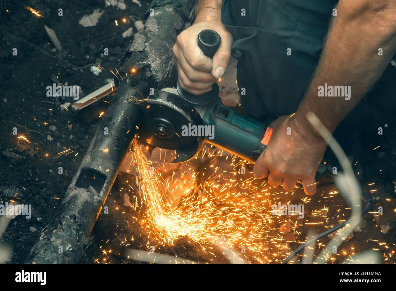 Arbeiter schneidet Gasleitung mit Mahlwerk, Nahaufnahme. Stockfoto