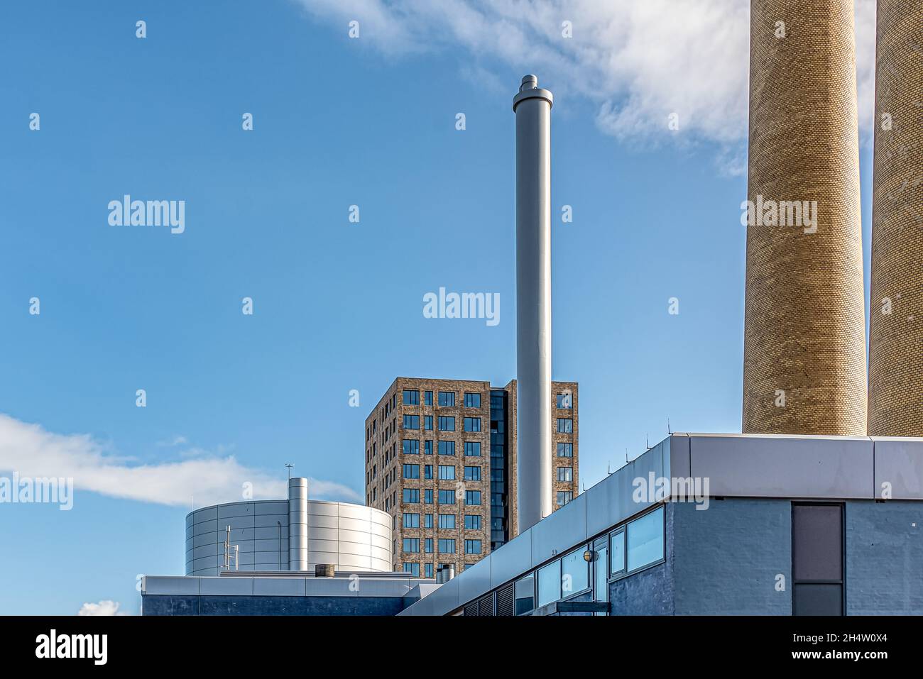Neuer Wohnblock hinter den Schornsteinen eines Kraftwerks in Frederikssund, Dänemark, 23. Oktober 2021 Stockfoto