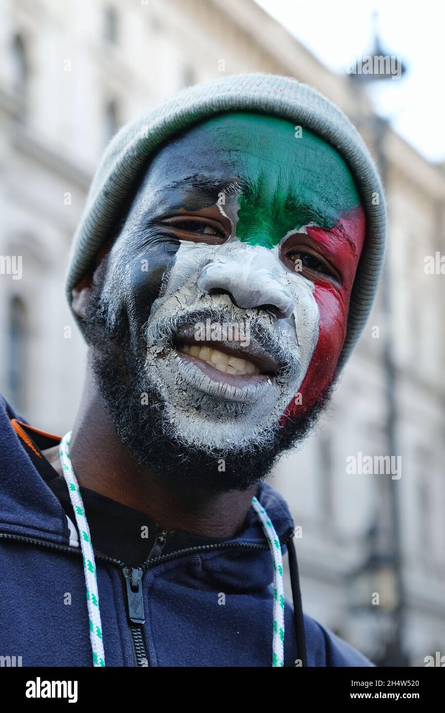 London, Großbritannien. Ein Protestler, dessen Gesicht in den Farben der sundanesischen Flagge gemalt ist, demonstriert gegen den Militärputsch in Whitehall. Stockfoto