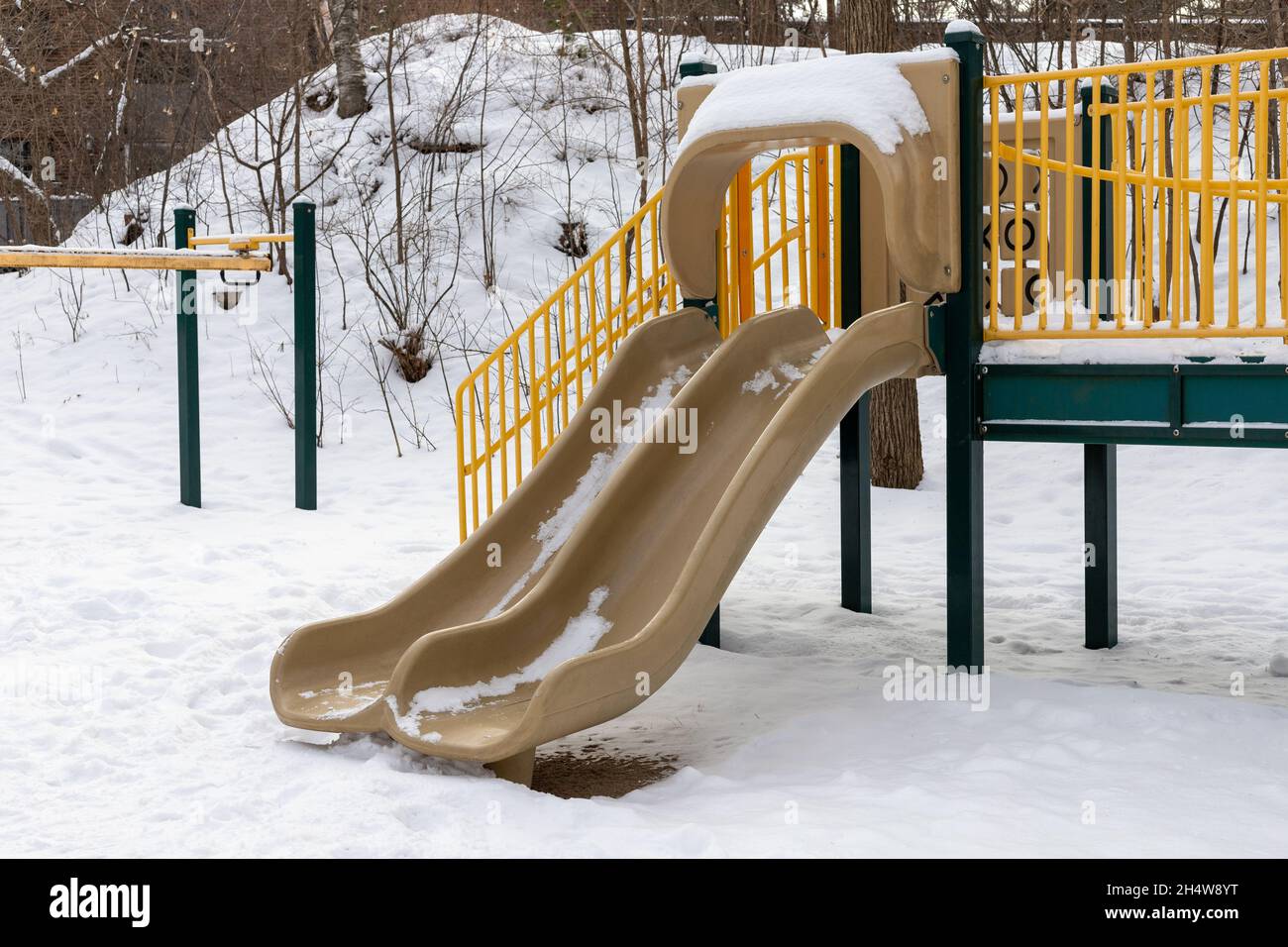 Spielplatz Rutsche im Park ohne Kinder, im Winter mit Schnee bedeckt Stockfoto