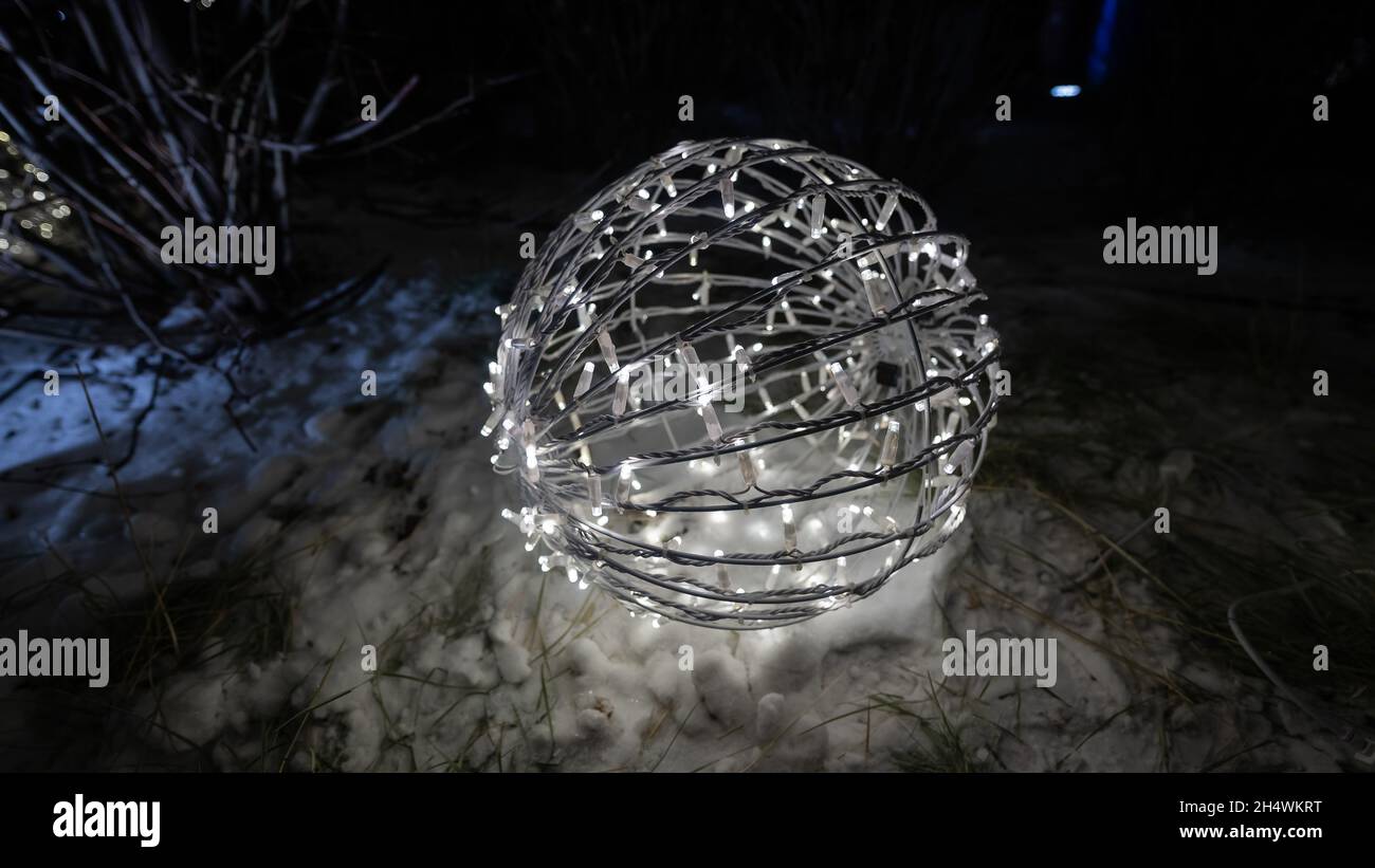 Weihnachtslichter in Form eines Balls auf dem Schnee. Stockfoto