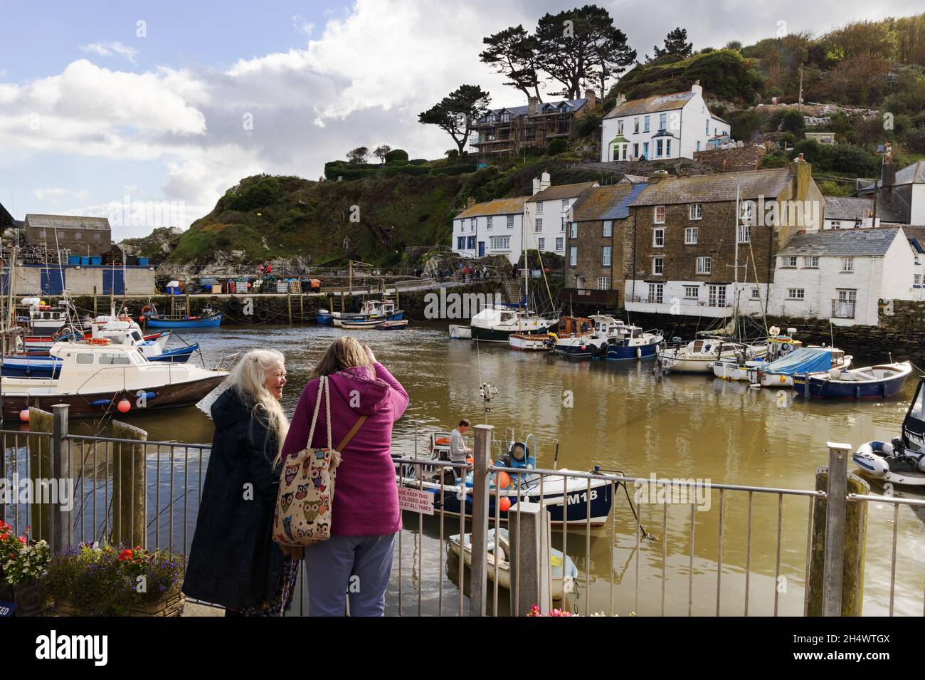Staycation UK; Cornwall-Touristen; Besucher, die den Hafen von Polperro an einem sonnigen Herbsttag betrachten, Polperro, Cornwall England Stockfoto