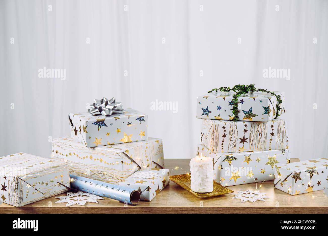Minimalistisches Weihnachten präsentiert Hintergrund. Stapel eingewickelter Weihnachtsgeschenke auf dem Tisch. Unterer Abschnitt gefüllt und viel Platz für Kopien auf dem oberen Abschnitt. Stockfoto