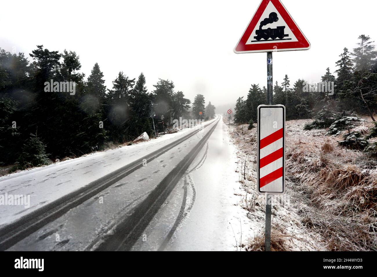 Schierke, Deutschland. November 2021. Reifenspuren sind im Schnee auf der Brocken-Straße zu sehen. In den hohen Lagen des Harzes gab es heftigen Schneefall. Quelle: Matthias Bein/dpa-Zentralbild/ZB/dpa/Alamy Live News Stockfoto