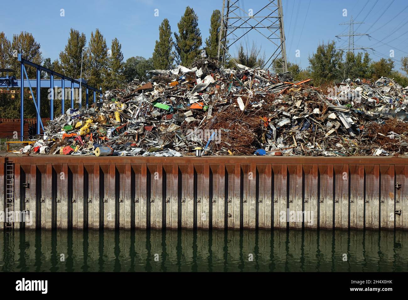 Schrottplatz mit buntem Schrott unter einer Stromleitung, Rheinhafen Karlsruhe, Mühlburg, Karlsruhe, Baden-Württemberg, Deutschland Stockfoto