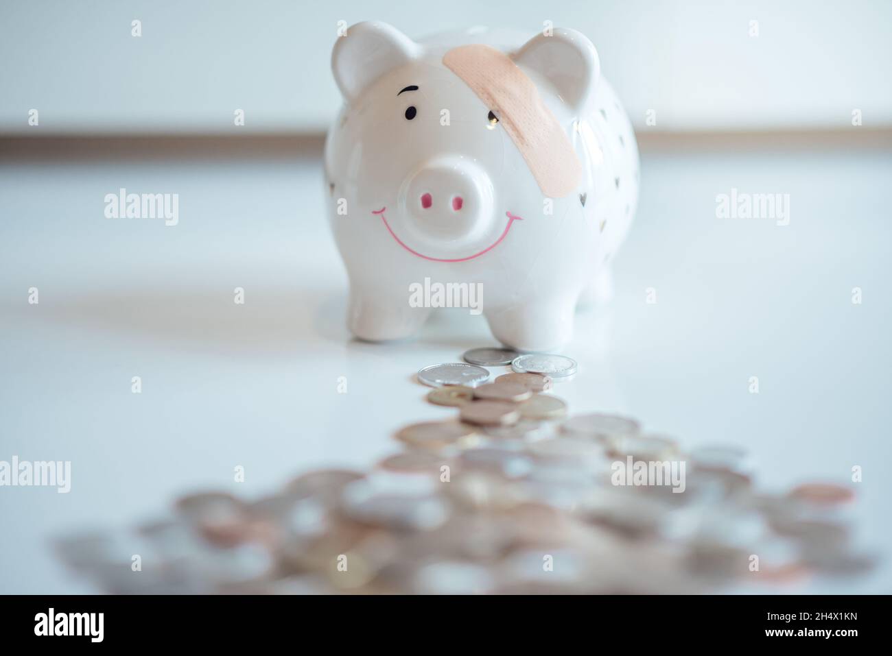 Das Sparschwein mit einem Pflaster mit vielen Münzen. Finanzielle Liquidität der Banken. Stockfoto