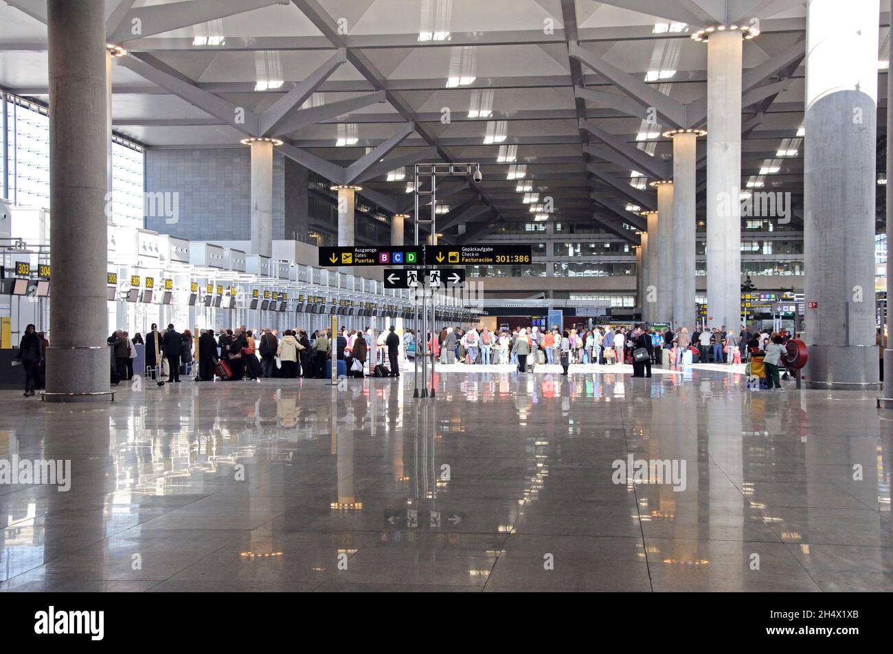 Passagiere, die auf den Check-in für Flüge in der Abflughalle von Terminal 3 am Flughafen Malaga, Malaga, Costa del Sol, Spanien warten Stockfoto