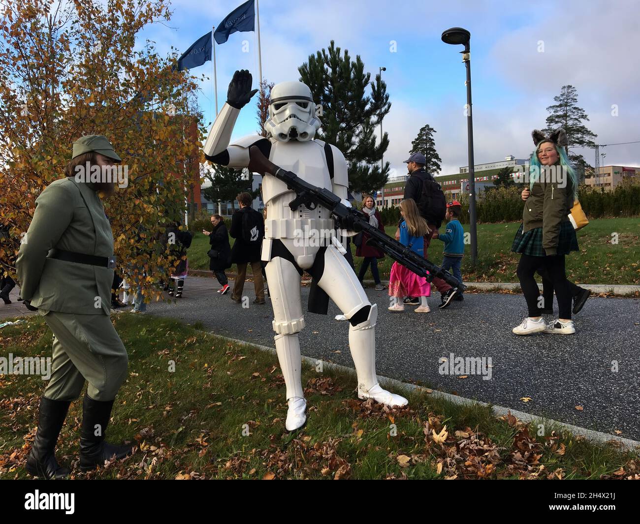 Bewaffneter Star Wars-Held Stormtrooper und AT-AT-Fahrer grüßt während der Patrouille auf der Straße in der Nähe der COSPLAY-Ausstellung COMIC-CON 2021, Helenelund, SE. Stockfoto