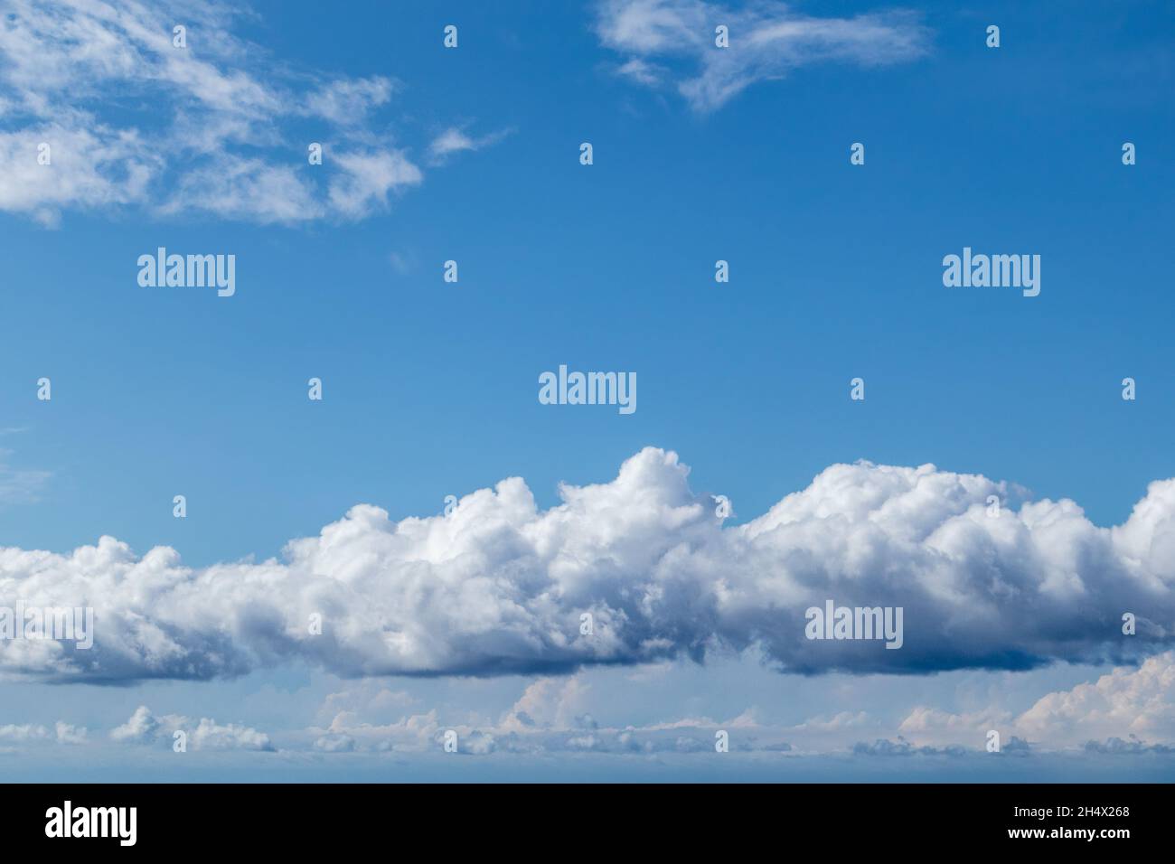 Fluffige weiße hohe Wolken auf hellem, leuchtendem blauen Himmel, Wolkenlandschaft Hintergrund. Skyscape natürliche himmlische Landschaft im Sommer Stockfoto