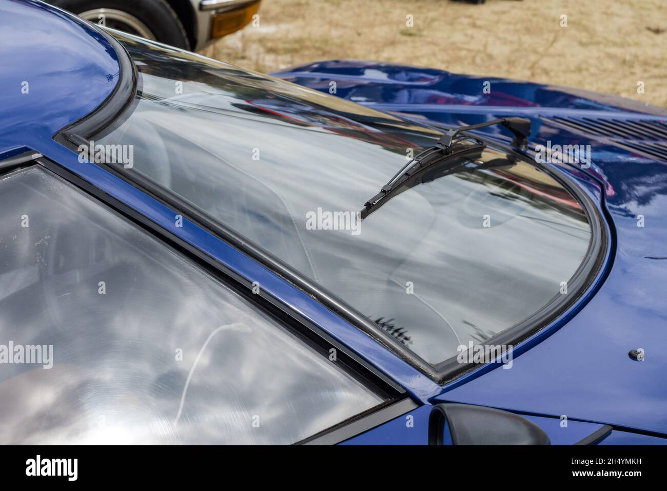 Nahaufnahme der gekrümmten Windschutzscheibe und des Scheibenwischers eines blauen Lancia Stratos HF Stradale klassischen italienischen Sport-Rallye-Autos. Stockfoto