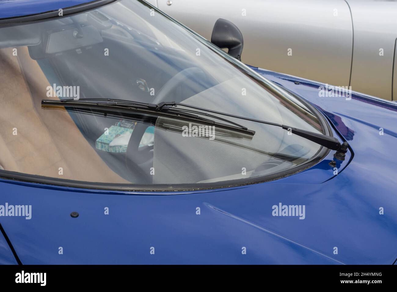 Nahaufnahme der gekrümmten Windschutzscheibe und des Scheibenwischers eines blauen Lancia Stratos HF Stradale klassischen italienischen Sport-Rallye-Autos. Stockfoto