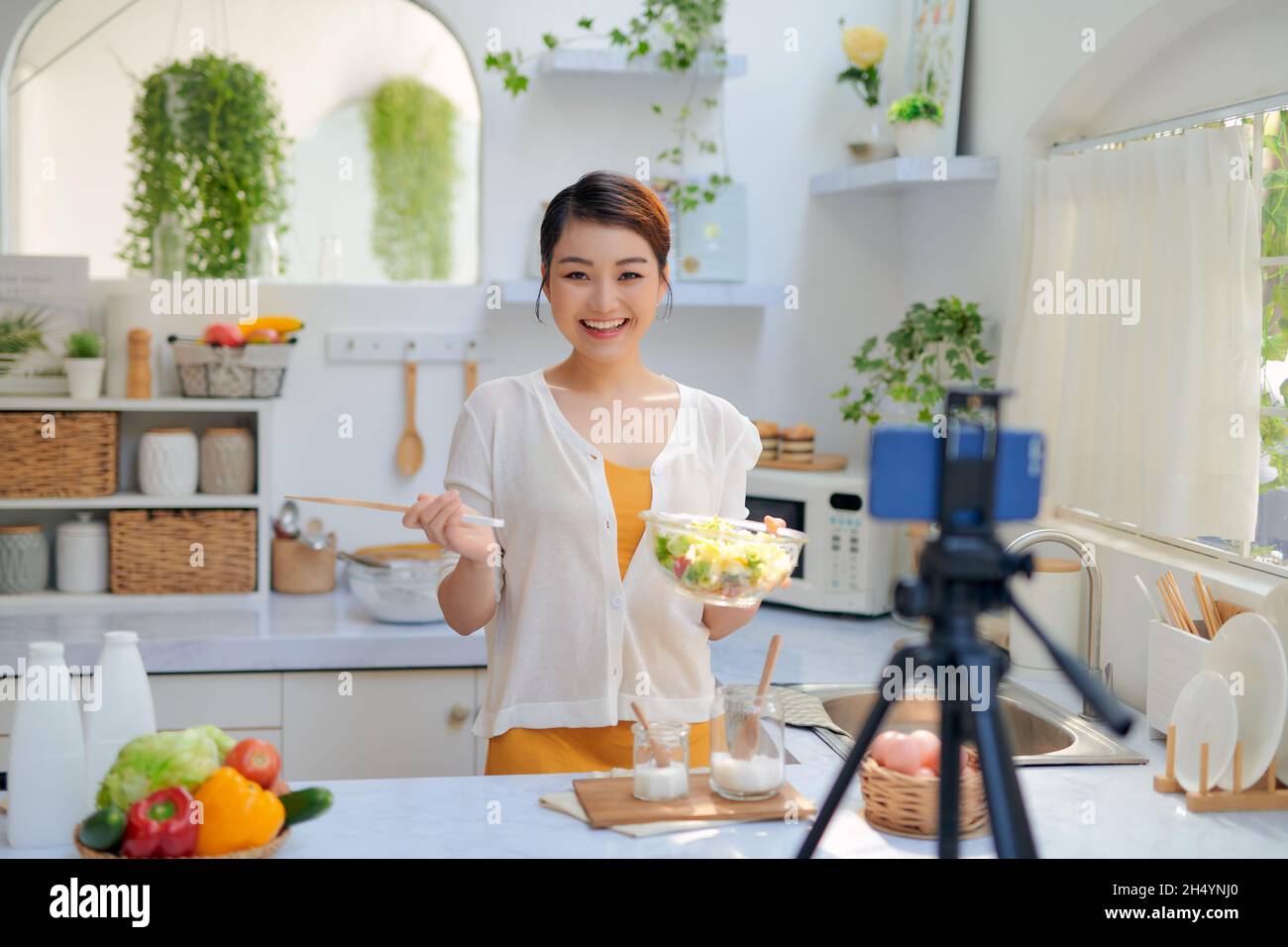 Food-Blogger, der Videos mit einer Telefonkamera in der heimischen Küche aufzeichnet Stockfoto