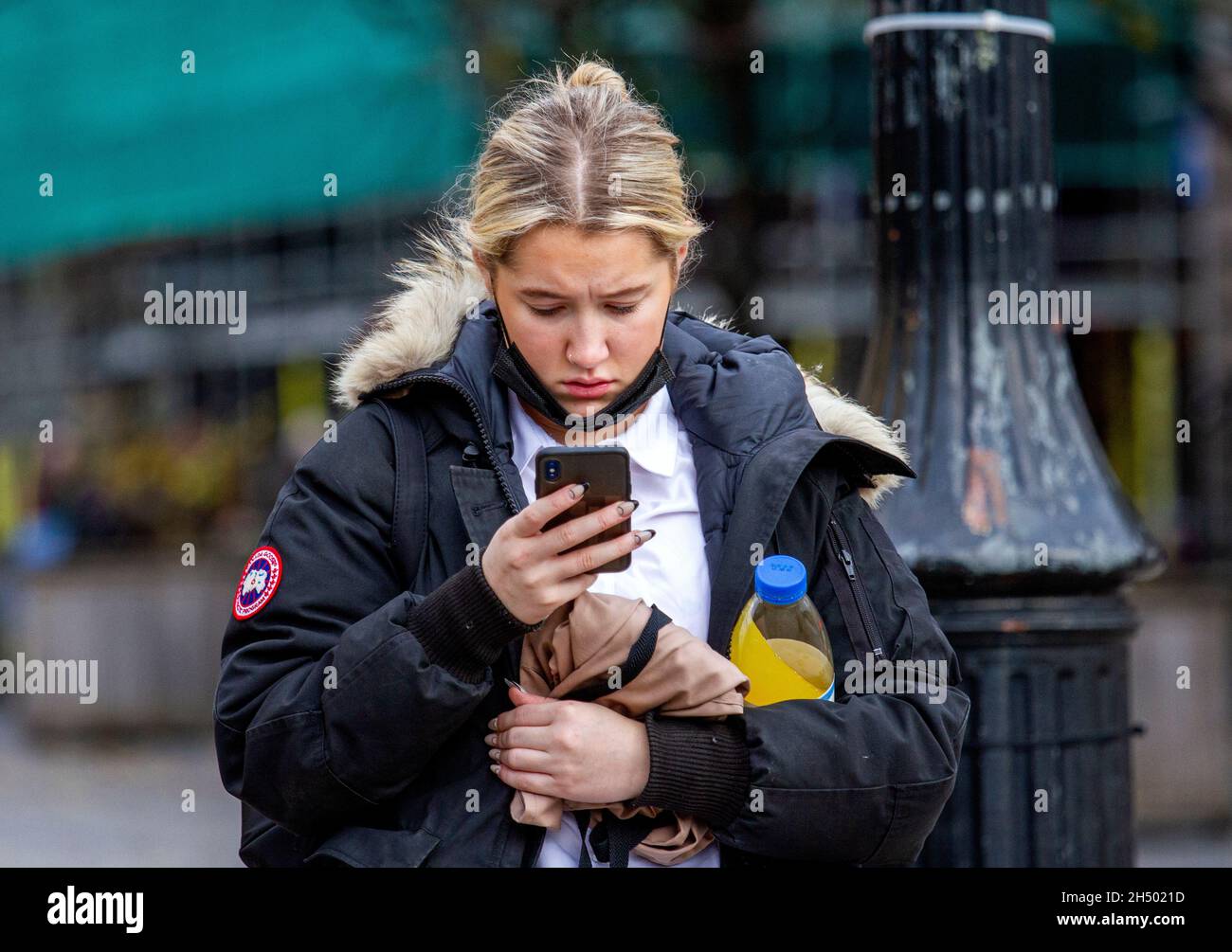 Dundee, Tayside, Schottland, Großbritannien. November 2021. UK Wetter: Kühles, helles Novemberwetter in Nordostschottland mit Temperaturen bis zu 12 Grad Eine attraktive junge Frau schreibt Nachrichten auf ihr Mobiltelefon, während sie den Tag draußen verbringt und das Herbstwetter im Stadtzentrum von Dundee genießt. Kredit: Dundee Photographics/Alamy Live Nachrichten Stockfoto