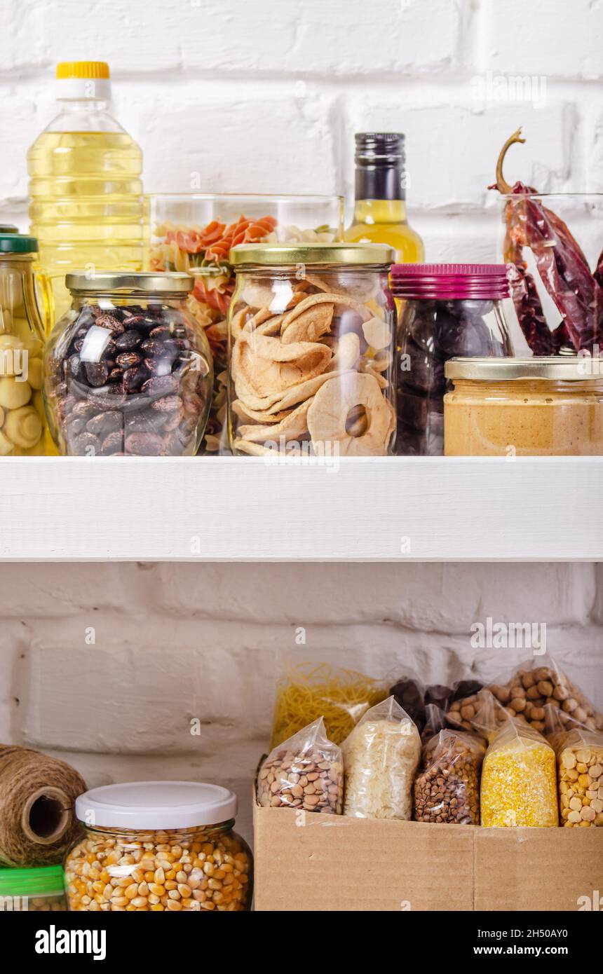 Set von nicht verderblichen Lebensmitteln auf Speisekammer Regal auf Backstein Wand Hintergrund Stockfoto