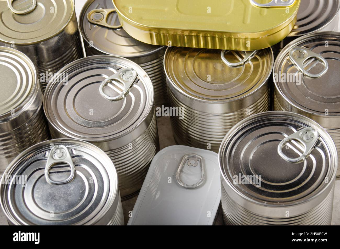 Set von verschiedenen Konserven in Dosen auf Küchentisch, nicht verderbliche, lange Haltbarkeit Lebensmittel für das Überleben in Notsituationen Konzept Stockfoto