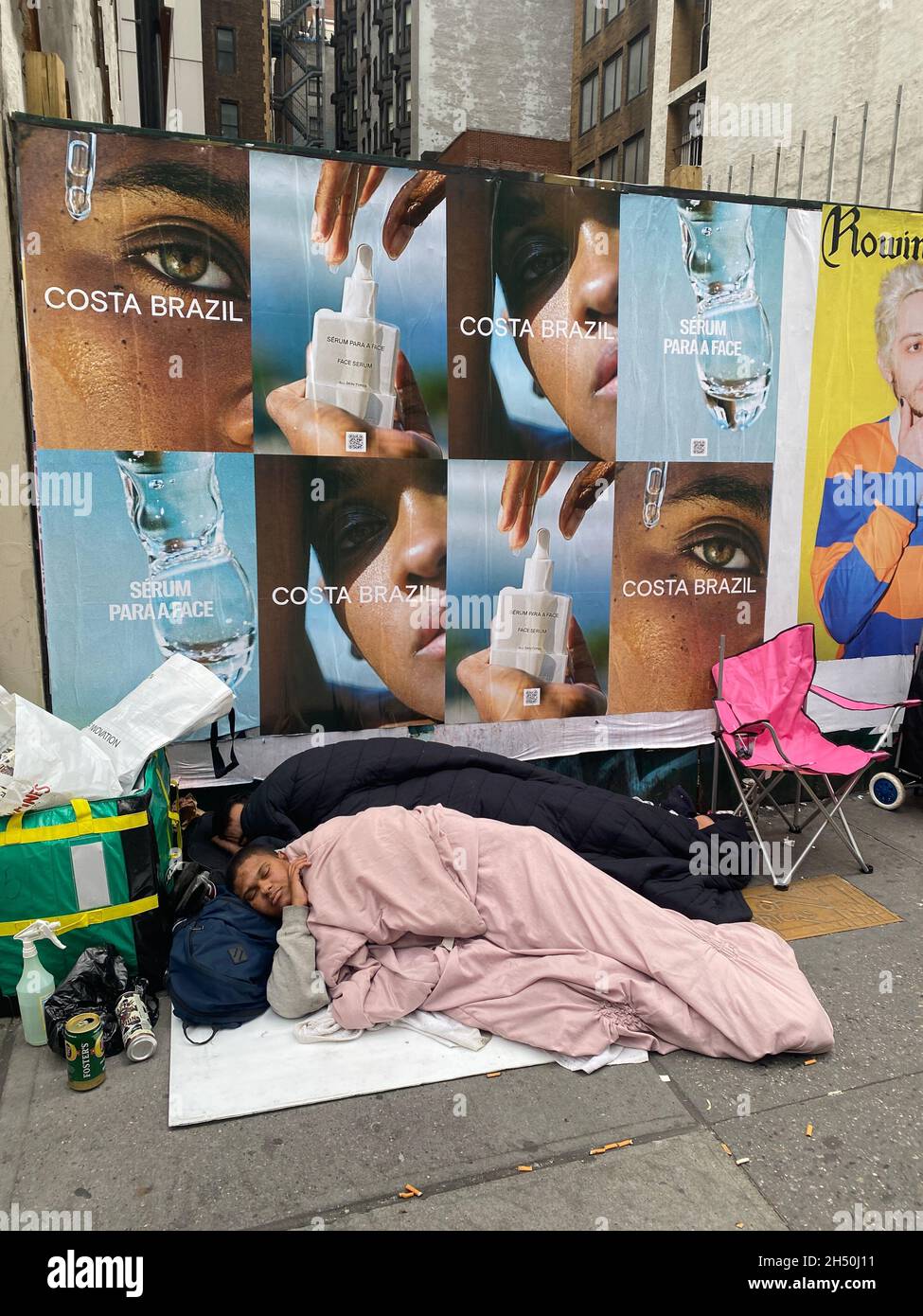 Zwei Obdachlose schlafen am Nachmittag in New York City an der 6th Avenue in der Midtown Manhattran. Stockfoto
