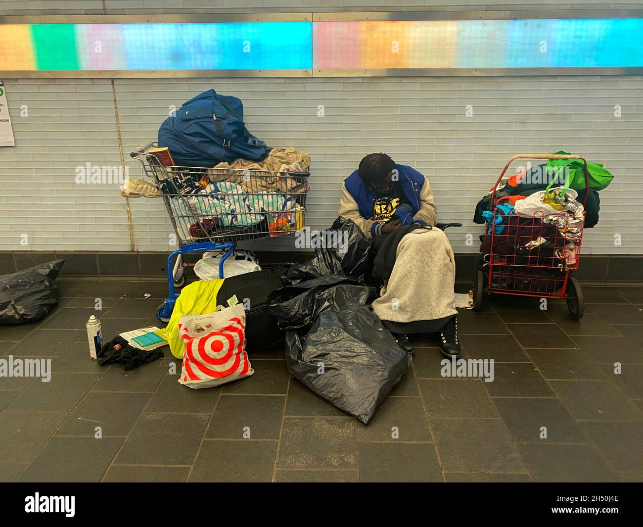 Obdachloser mit all seinen Habseligkeiten lagerten sich in einem der Passanten im Grand Central Terminal in New York City. Stockfoto