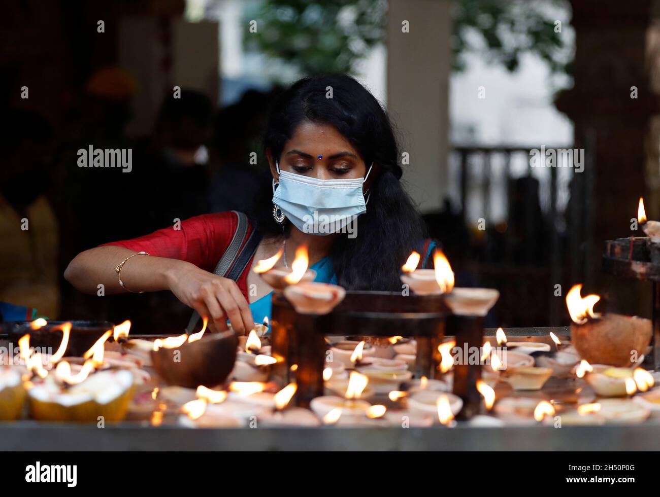 Kuala Lumpur, Malaysia. November 2021. Ein Hindu-Anhänger sah während des Festivals Öllampen anzünden, während er im Tempel der Batu Caves bete.Diwali ist eines der wichtigsten religiösen Feste im Hinduismus. Die Göttin Lakshmi, der gott des Reichtums, wird während Diwali für Glück, Wohlstand und Ruhm verehrt. Kredit: SOPA Images Limited/Alamy Live Nachrichten Stockfoto