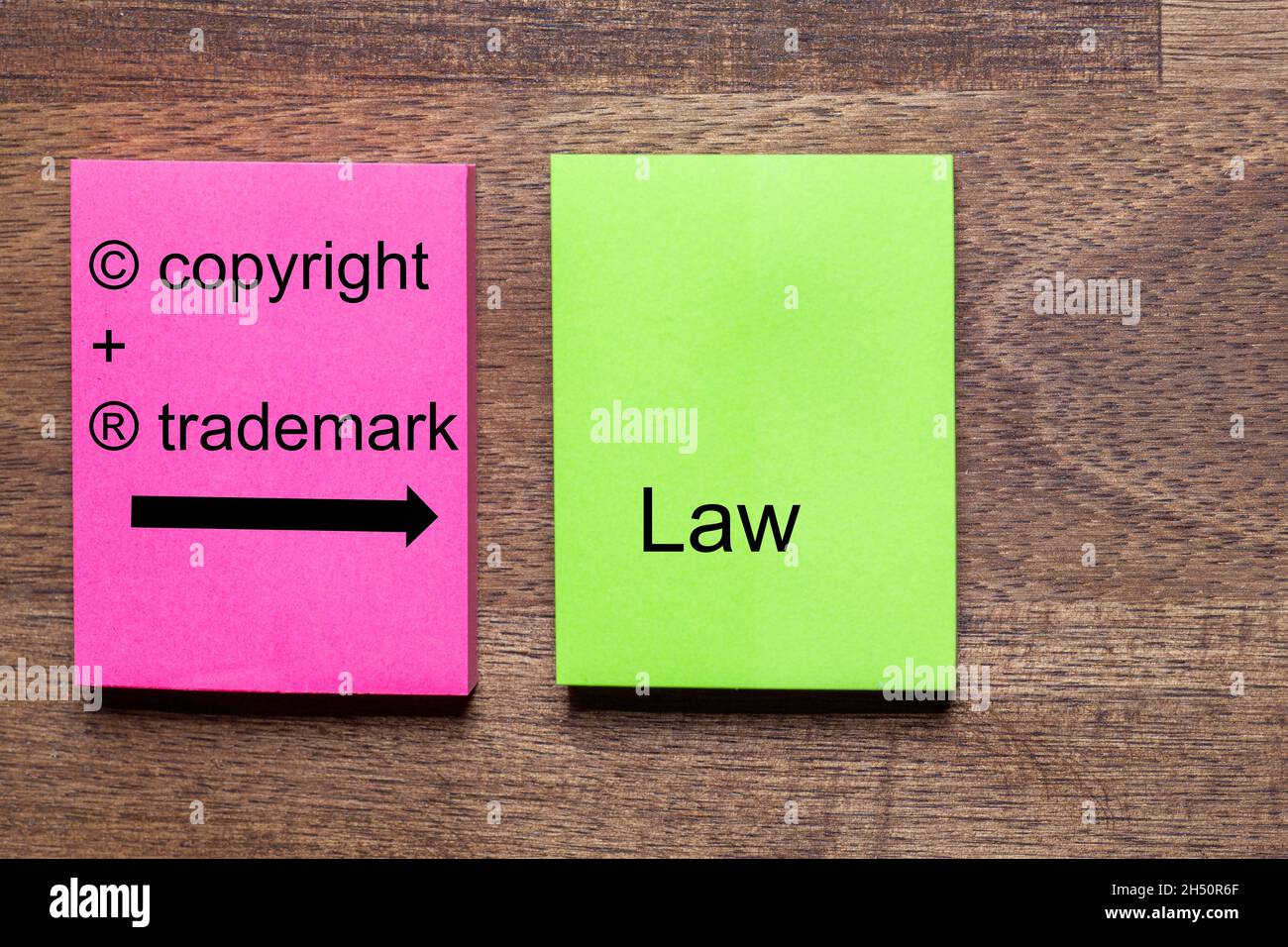Das Urheber- und Markenrecht ist auf einem roten und grünen Aufkleber auf einem dunklen Holztisch angebracht Stockfoto