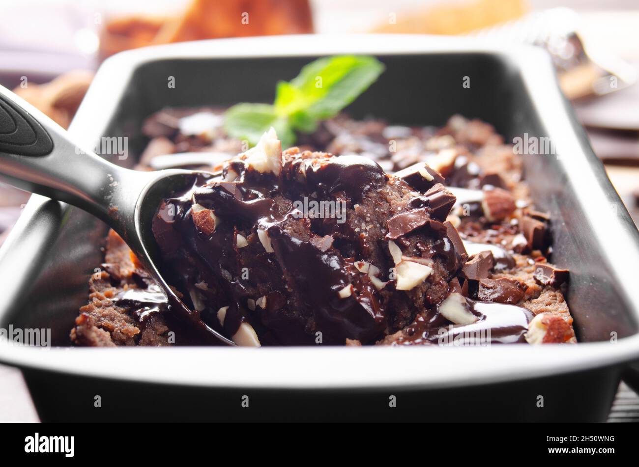 Schokoladeneis in Metallschale mit Minzblatt und Mandelnüssen Stockfoto