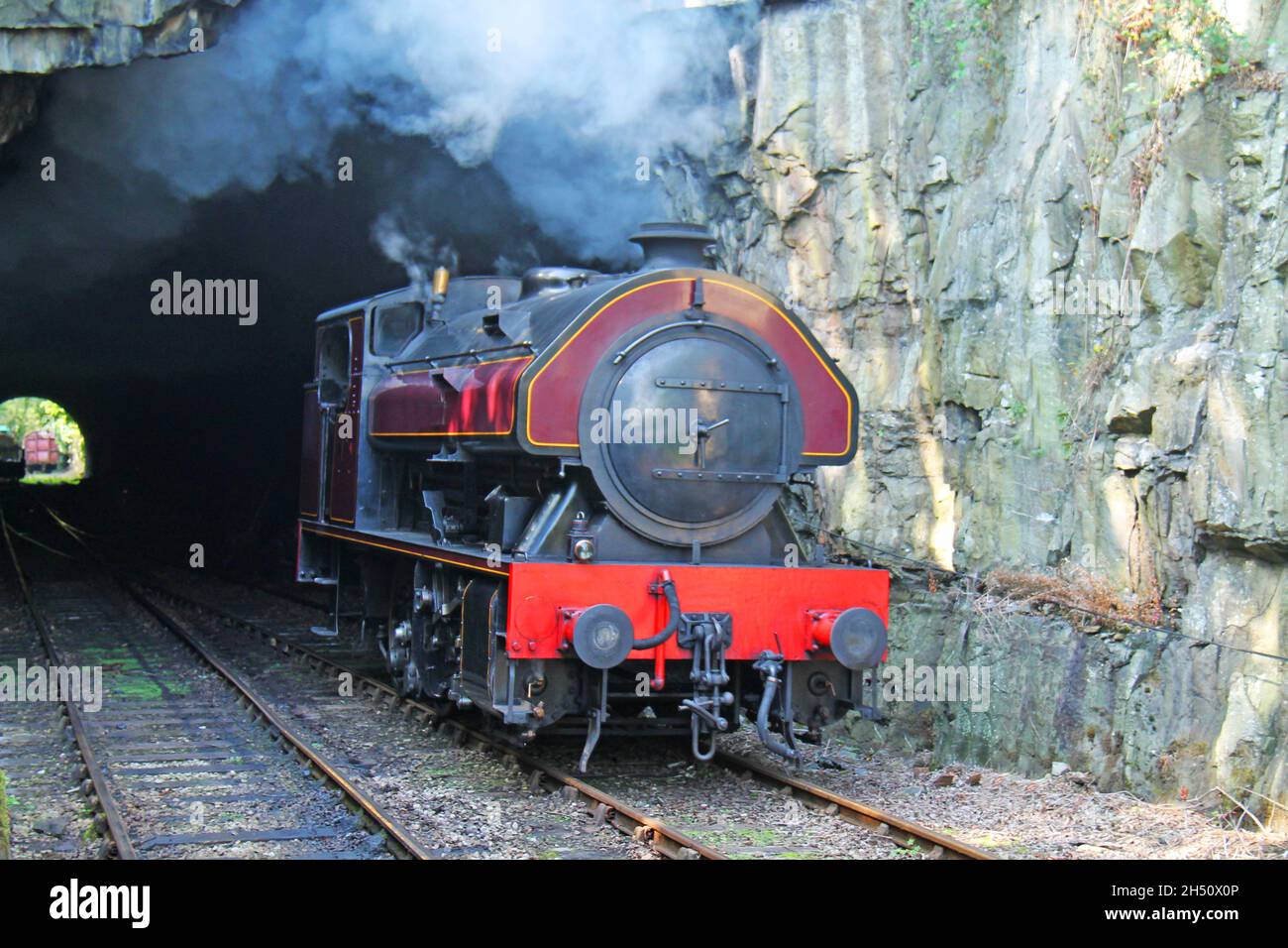 Ein Vintage Saddleback Dampfzug, der einen Tunnel verlässt. Stockfoto
