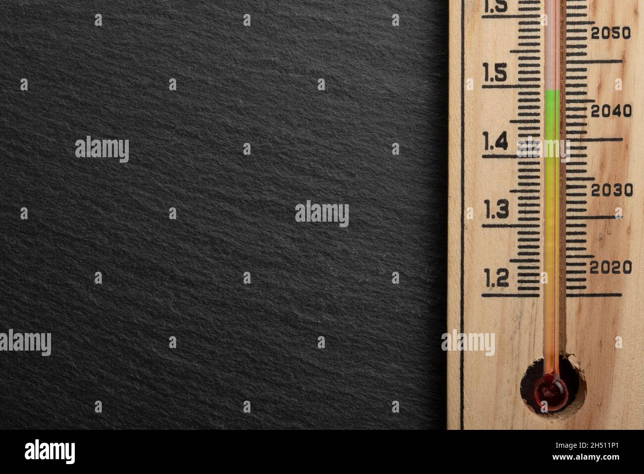 1.5 Grad Pariser Abkommen Konzept: Ein Thermometer auf einem Felstisch mit Skala, die Daten und steigende Temperaturen zeigt Stockfoto
