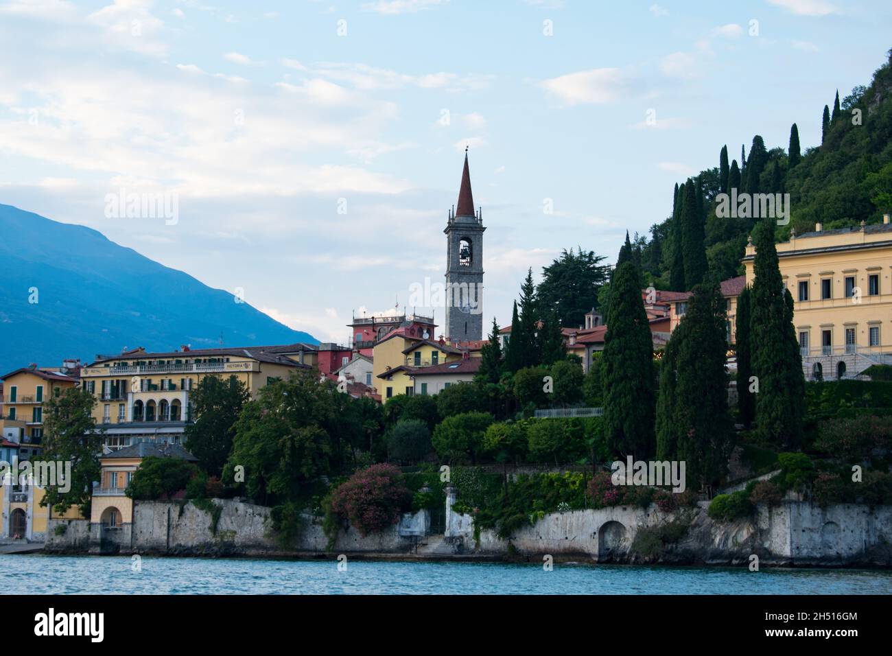 Berühmter Glockenturm im Zentrum von Varenna Italien am Comer See. Schöner botanischer Garten mit rosa mediterranen Oleander Blumen dekoriert- Varenna, L Stockfoto