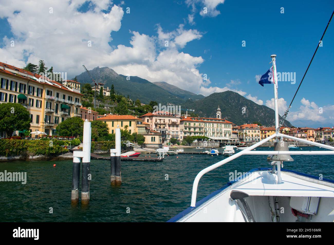 Atemberaubendes Panorama des Comer Sees, Italien von einer Wasserfähre aus. Flagge mit Lago de como im Vordergrund. Region Lombardei, Europa, Alpen. Italienische Flagge Stockfoto