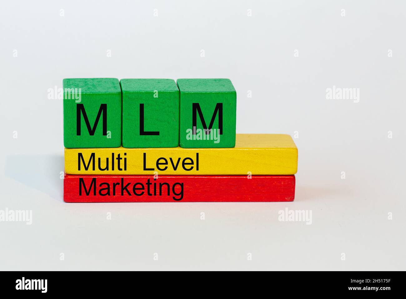 MLM ist die Abkürzung für Multi Level Marketing und steht auf bunten Spielzeugblöcken isoliert vor weißem Hintergrund Stockfoto