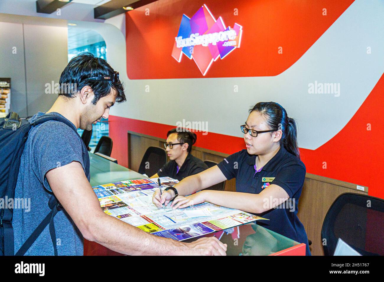 Singapore Changi International Airport Terminal Gate, Touristeninformationsschalter, Mann männlich asiatisch Frau weiblich Karte helfend Stockfoto