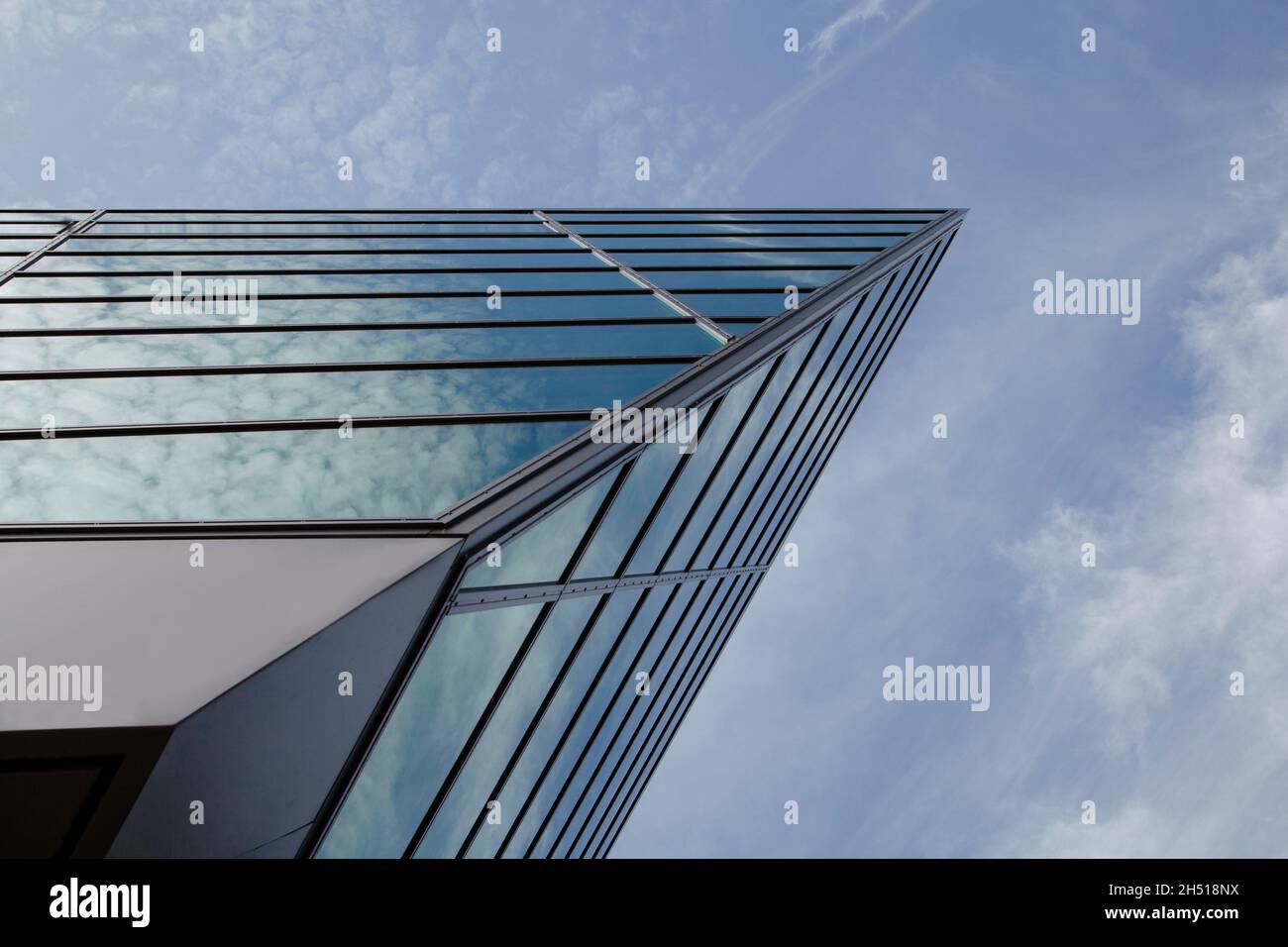 Glasfassade als Dreieck auf einem Gebäude von unten Stockfoto Glasfassade als Dreieck auf einem Gebäude von unten Stockfoto