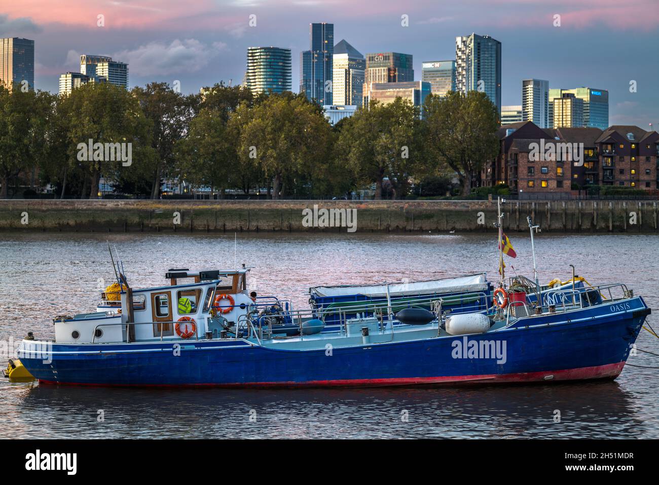 Süßwasserbunkerschiff Oasis an der Themse, Greenwich, London, England, Vereinigtes Königreich, GB mit Blick auf Canary Wharf, auf der Isle of Dogs Stockfoto