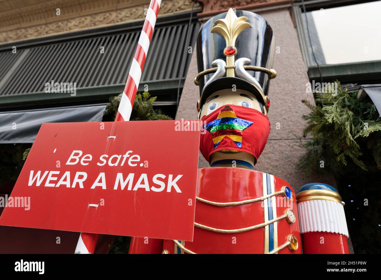 Weihnachten, Weihnachtseinkäufe während des COVID Tragen von Masken und soziale Distanzierungsanforderungen, Schild vor dem Einkaufszentrum Stockfoto