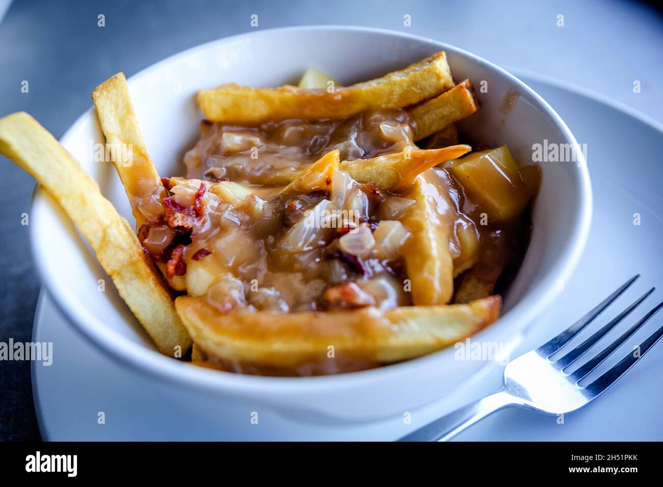 Pommes frites in Soße erstickt. Stockfoto