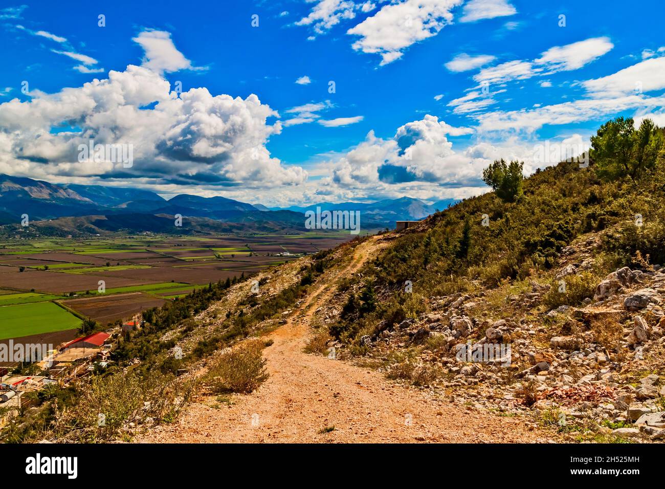 Berg felsigen Weg in Balkangebirge im Süden Albanien, Saranda, Vlora Bezirk in sonnigen heißen Sommertag. Blauer Himmel, weiße Wolken. Blick auf grün f Stockfoto