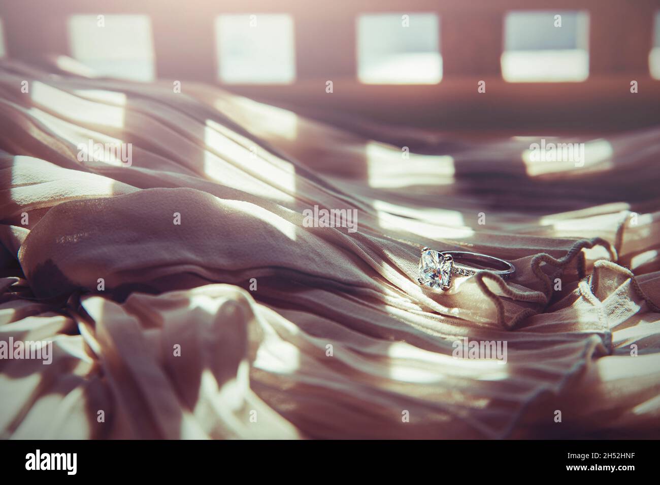 Nahaufnahme des eleganten Diamantrings auf grauem Schal-Hintergrund. Luxus Diamanten Schmuck Accessoire. „I Love You Darling“-Konzept. Stockfoto