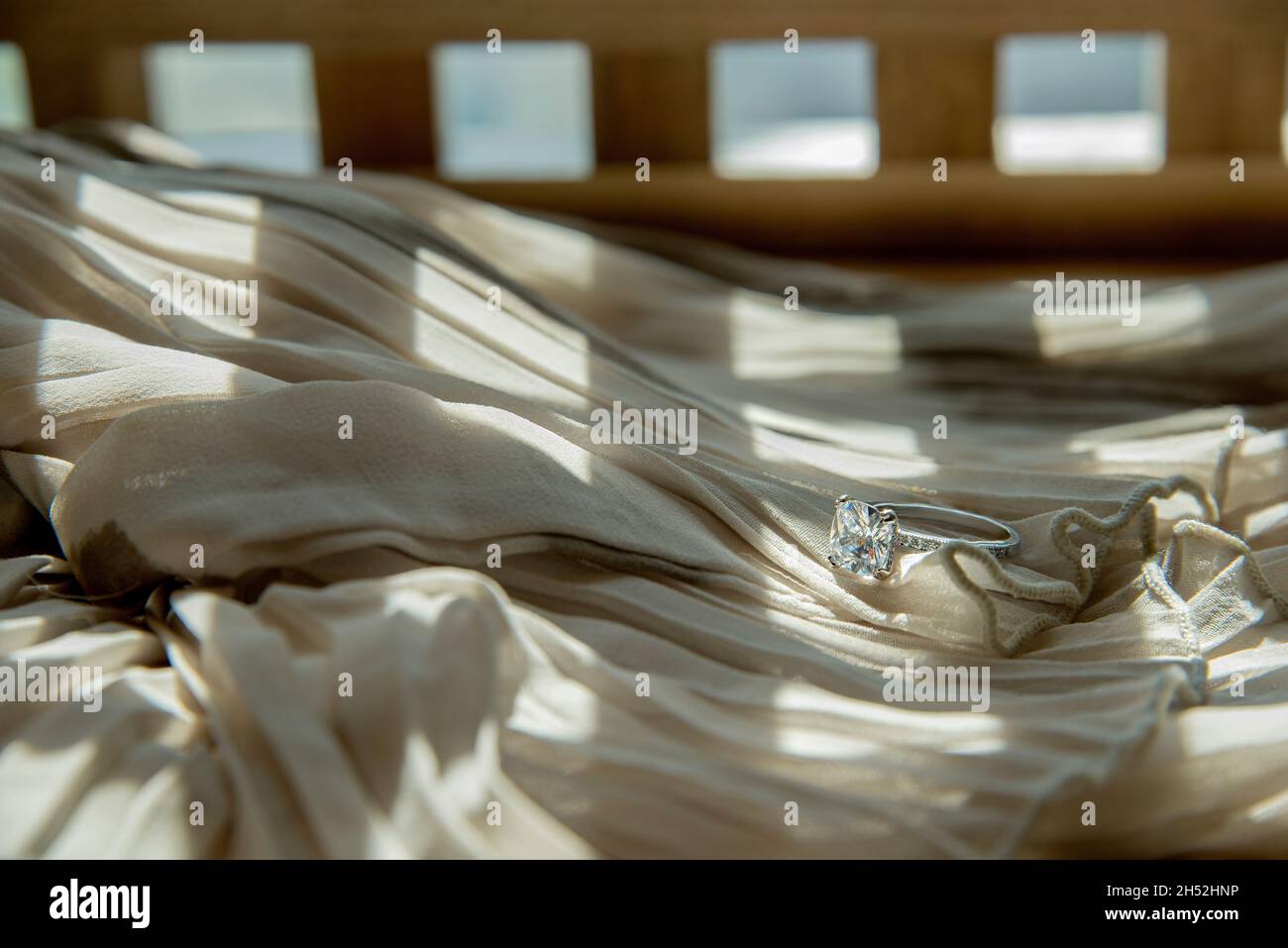 Nahaufnahme des eleganten Diamantrings auf grauem Schal-Hintergrund. Luxus Diamanten Schmuck Accessoire. „I Love You Darling“-Konzept. Stockfoto