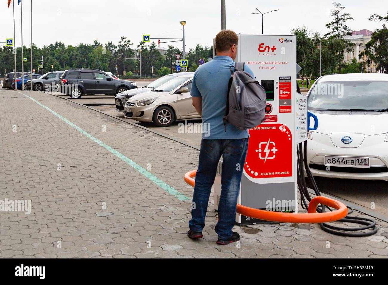 Irkutsk, Russland - am 31. Juli 2021 lädt der Mensch sein Elektroauto. Redaktionell. Stockfoto