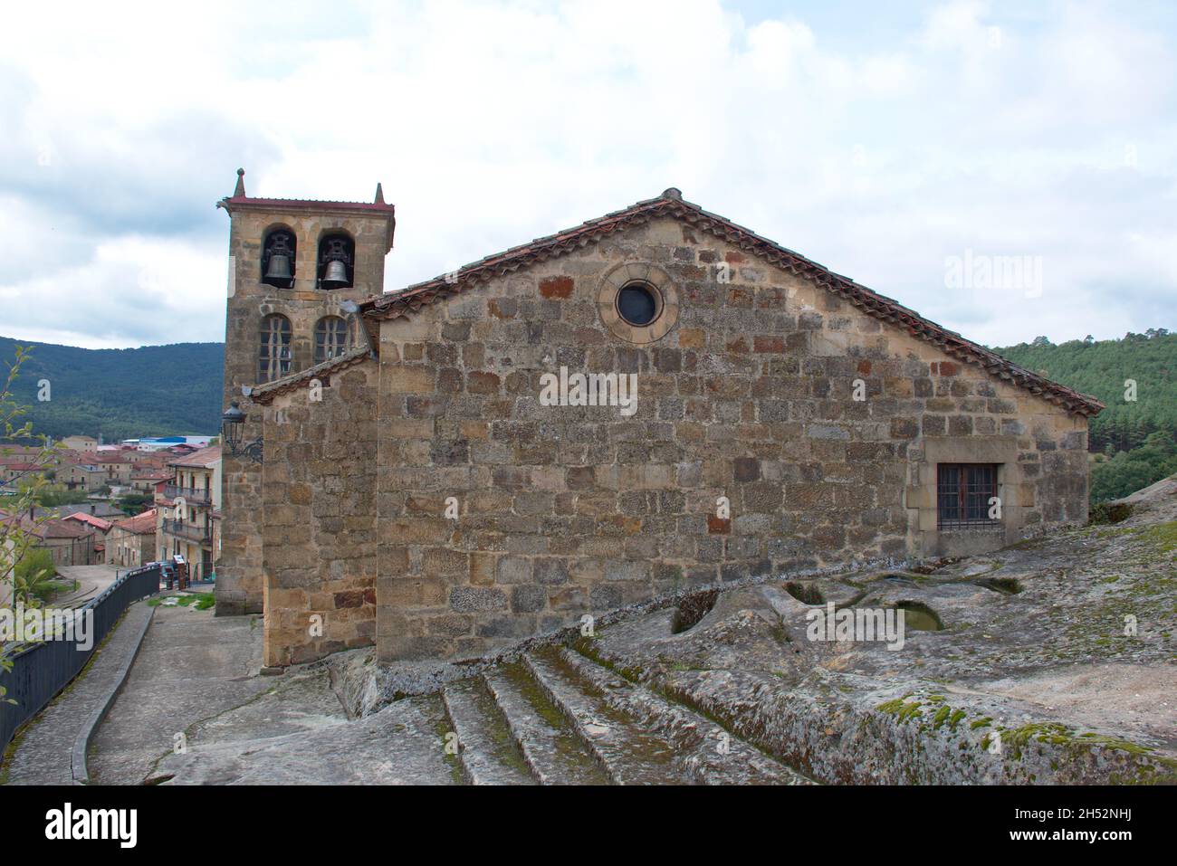 Rückansicht der Kirche San Adrian Martir im Dorf Regumiel de la Sierra, Provinz Burgos, Spanien. Unter ihm sind anthropomorphe Gräber aus Stockfoto