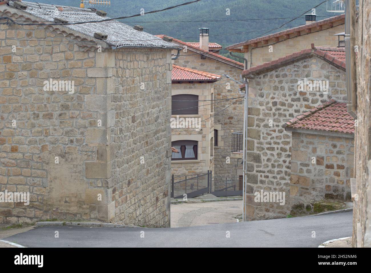 Straße und architektonische Details der Häuser. Dorf Regumiel de la Sierra, Provinz Burgos, Spanien. Stockfoto