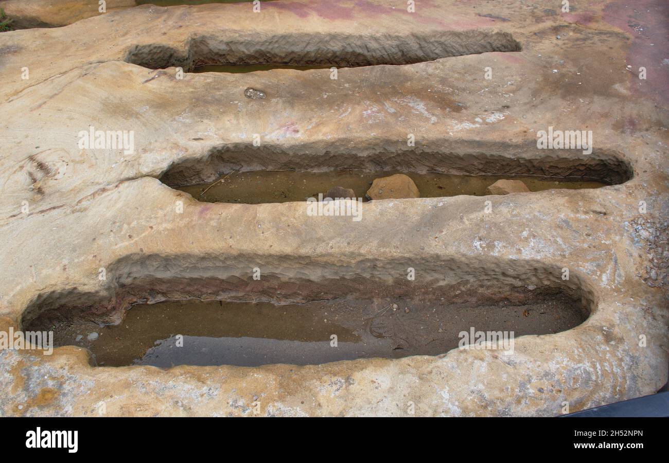 Detail von drei anthropomorphen Gräbern, die aus dem Sandstein geschnitzt wurden. Nekropole des Dorfes Regumiel de la Sierra, Burgos, Spanien. Stockfoto