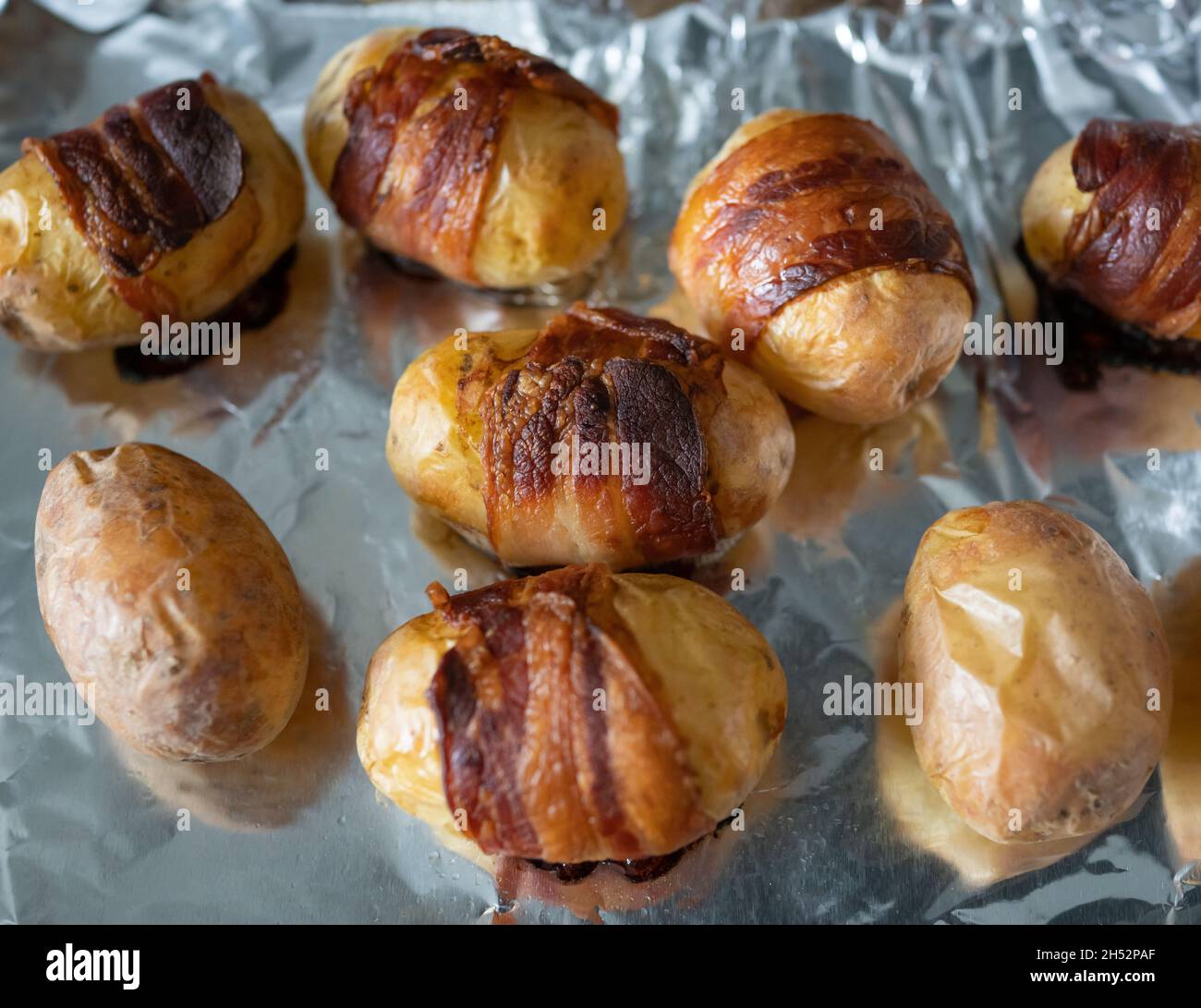 Leckere, überbackene, in Speck verpackte Mini-Kartoffeln Stockfoto