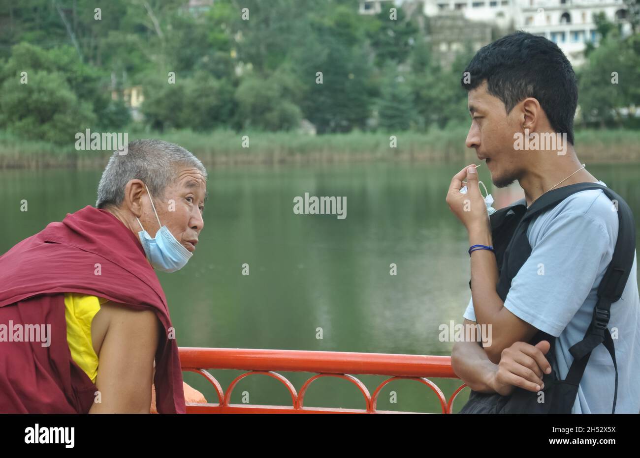 Mandi, Himachal Pradesh, Indien - 08 01 2021: Ein asiatischer junger Mann, der während einer Coronavirus-Pandemie im Freien mit lama (buddhistischer Mönch) gesprochen hat Stockfoto