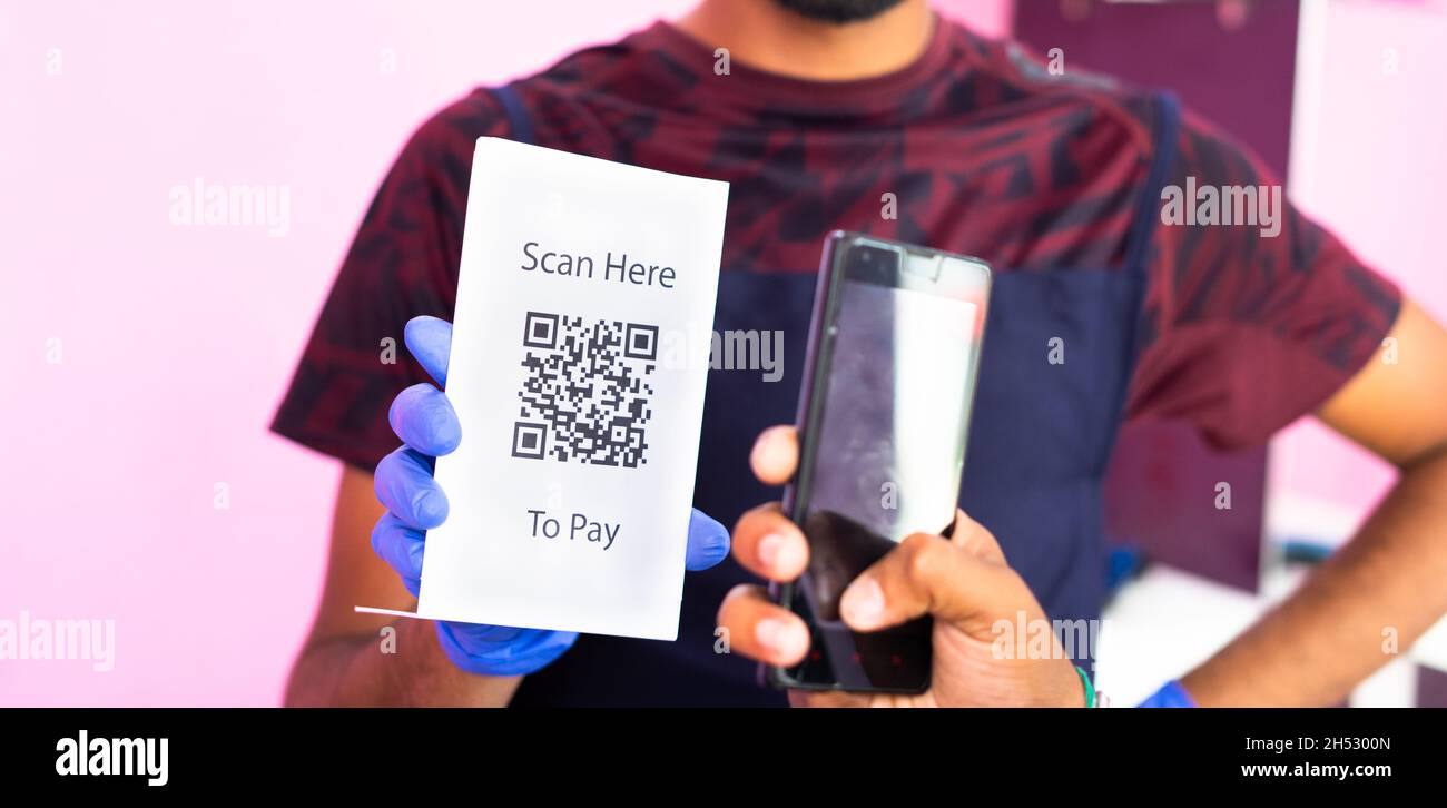 Unkenntlich Nahaufnahme des Kunden, der per QR-Code auf dem Smartphone an den Friseur zahlt – Konzept der E-Zahlung oder der digitalen Bezahlung, bargeldlos Stockfoto