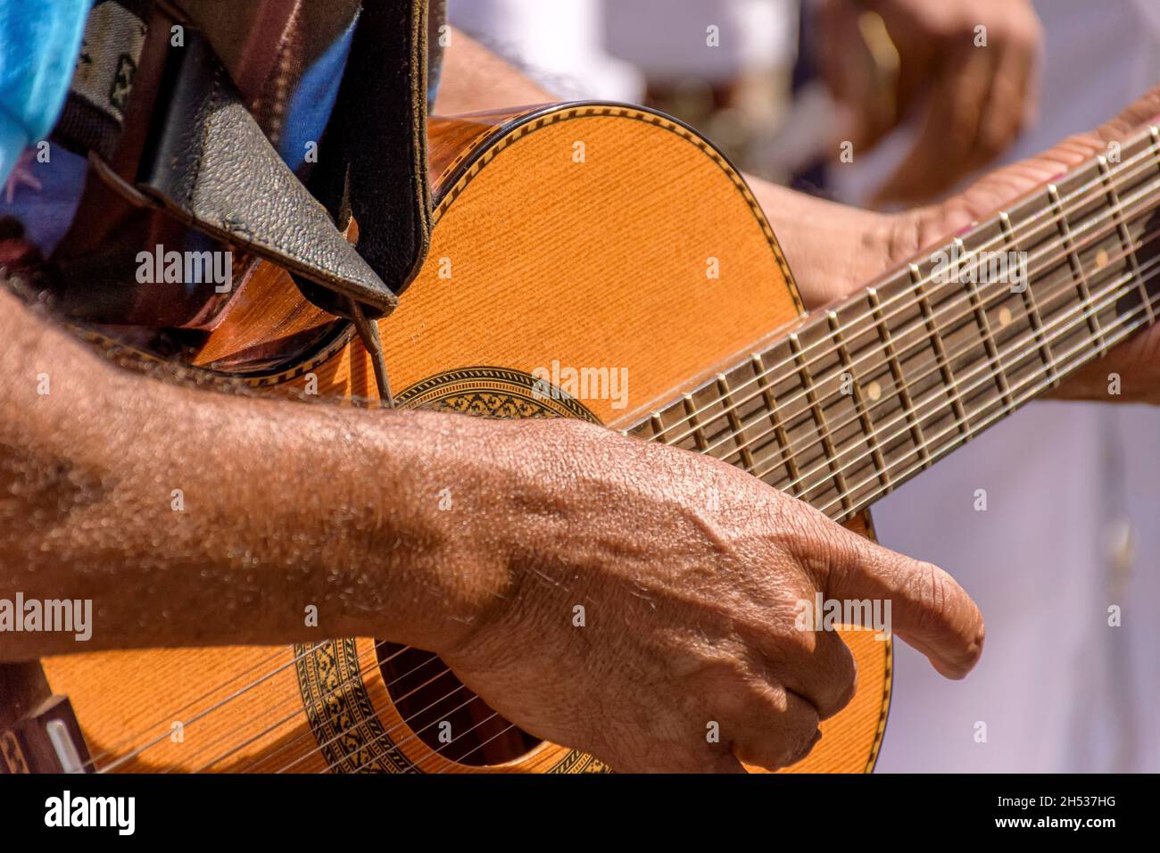 Detail der Hände des Gitarristen und seine akustische Gitarre bei einer Outdoor-Präsentation populärer Musik Stockfoto
