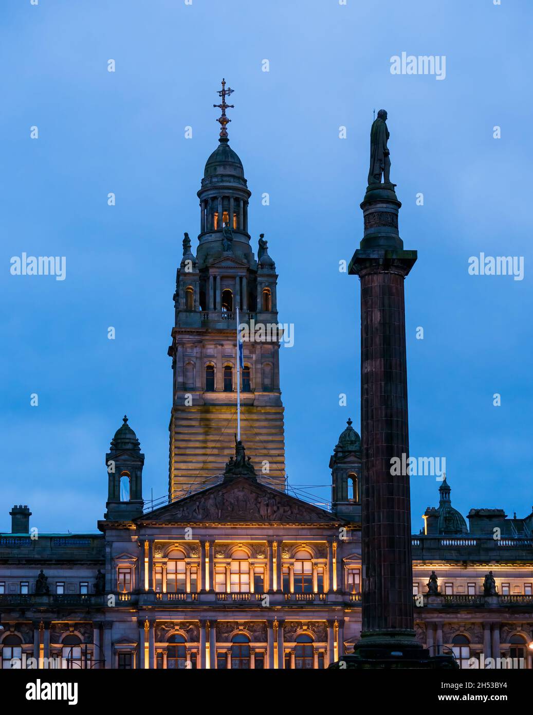Das Gebäude der City Chambers des Glasgower Rates leuchtete nachts mit einer Säulenstatue, George Square, Glasgow, Schottland, Großbritannien Stockfoto